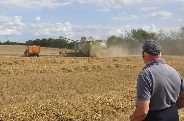 Combine Harvester at work in Bradfield St George with farmer in foreground